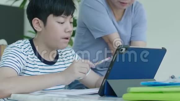 亚洲母亲正在控制她的儿子做家庭作业视频的预览图