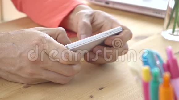 玫瑰粉色T恤商人聊天打字或玩智能手机视频的预览图