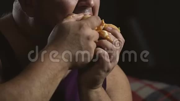乱七八糟的超重男人夹着油腻的汉堡包暴饮暴食的心理视频的预览图