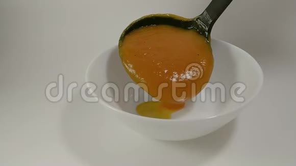 南瓜汤从勺子里倒进白盘里视频的预览图