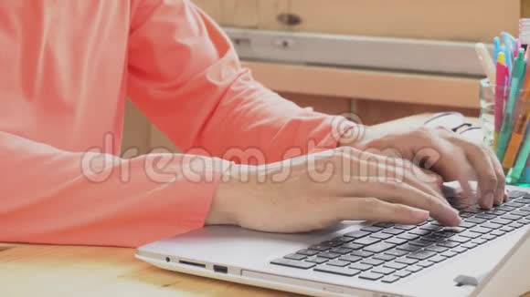 罗斯粉红色t恤商人在家办公室打字笔记本电脑通过互联网工作和交流视频的预览图