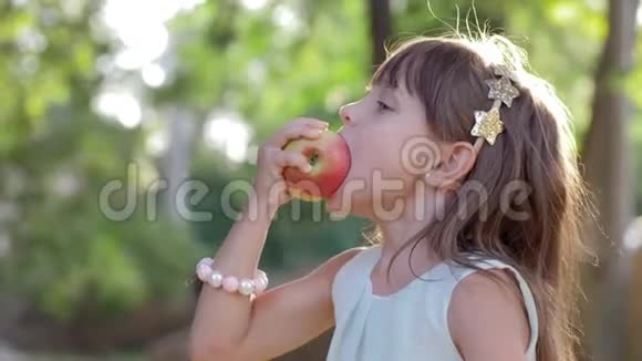 儿童健康食品可爱的小女孩吃苹果笑大自然视频的预览图