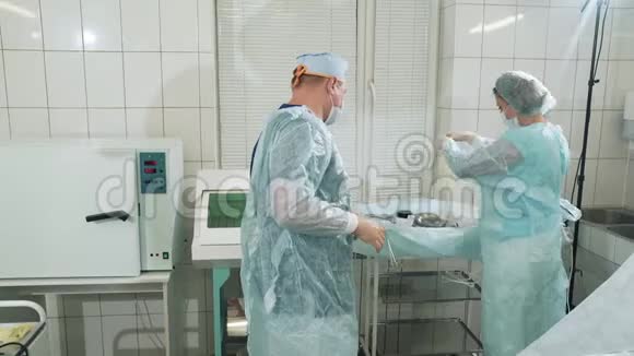 手术前外科医生戴上干净的手套护士帮助医生戴上医生正在准备视频的预览图
