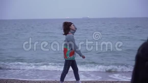 穿着牛仔夹克的情侣走在海边视频的预览图