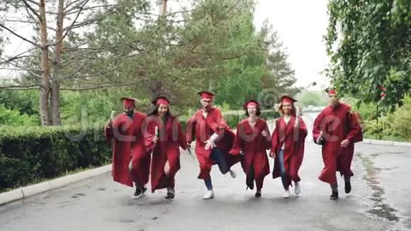 情绪低落的毕业生快乐的女孩和男人带着毕业证书跑着笑着漂亮的女孩正在起飞视频的预览图