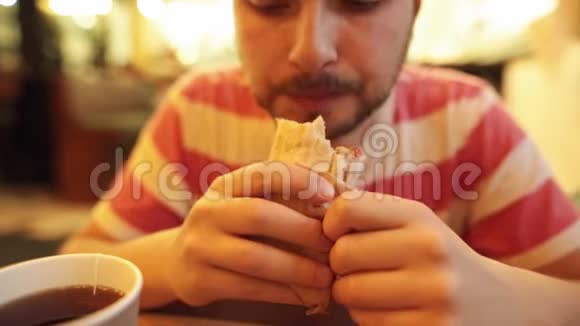 饥肠辘辘的留着胡子的人用煎肉吃着鲜甜的披肩视频的预览图