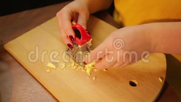 一个女人在粗磨砂上摩擦奶酪做沙拉视频的预览图
