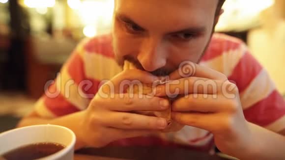嬉皮士正在吃一个美味多汁的鸡肉甜甜圈和茶玩得很开心视频的预览图