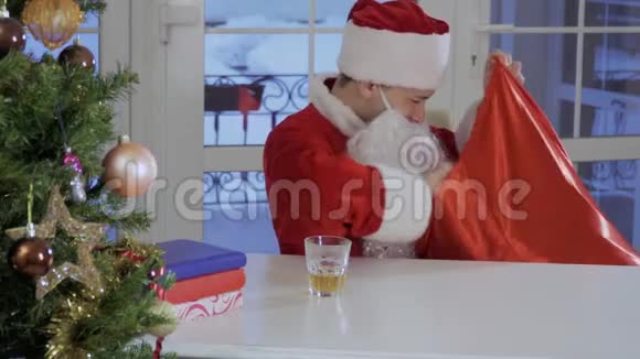 喝醉酒的圣诞老人从他的红包里拿出礼物视频的预览图