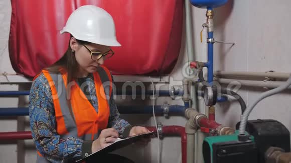 女工程师检查锅炉房的仪表读数视频的预览图