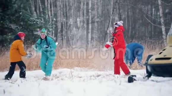 冬季森林在雪地摩托附近玩雪球的快乐家庭视频的预览图