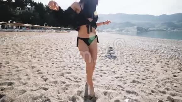穿着黑色比基尼泳衣的女孩在海边跳舞视频的预览图