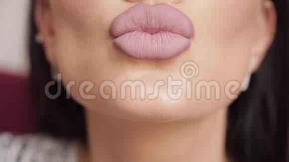 极致的特写丰满的女性性感嘴唇涂着裸口红亲吻和微笑视频的预览图