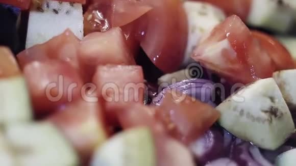 切菜的宏观视野西红柿洋葱和茄子正在被炒视频的预览图