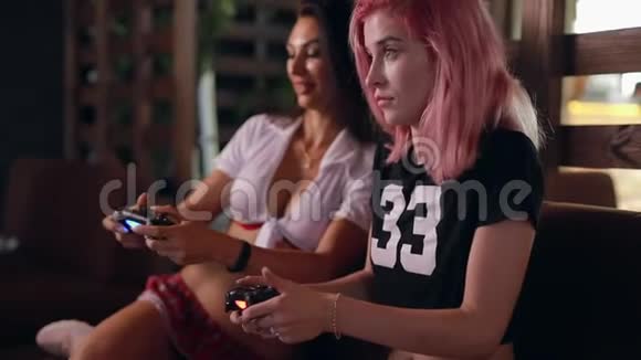 两个性感女孩在玩电视游戏拿着操纵杆视频的预览图