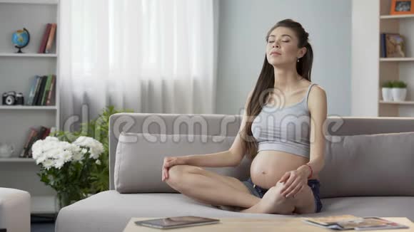 准妈妈坐在沙发上做怀孕瑜伽呼吸练习放松视频的预览图