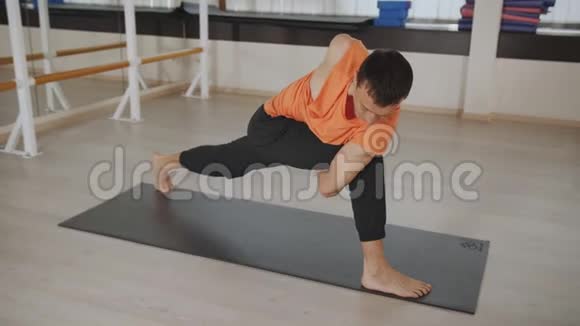 运动男在健身工作室练习阿什唐瑜伽视频的预览图