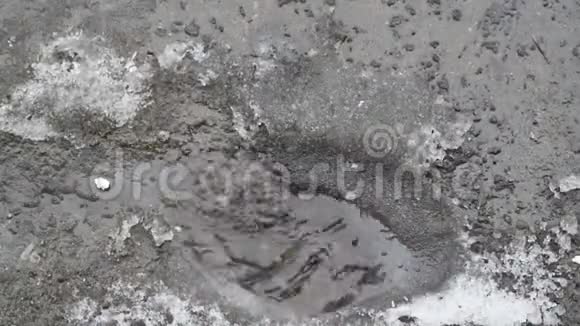 春天雪融化成水形成了溅起水花的水池视频的预览图