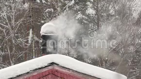 雪堆里的烟囱管道冬天用炉子白烟背景森林视频的预览图
