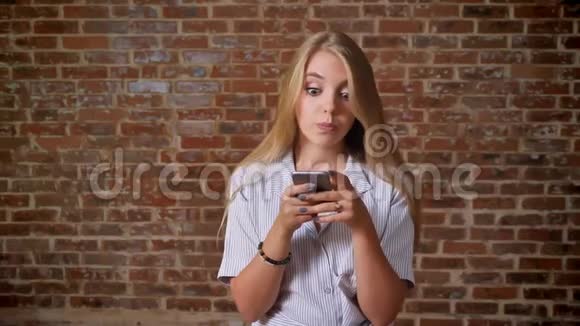 年轻的白种人金发女孩显示智能手机屏幕绿色屏幕推荐应用程序如标志肖像砖块视频的预览图