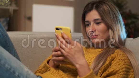 漂亮的金发女孩在手机上发短信使用智能手机的女性在社交中与朋友交流视频的预览图