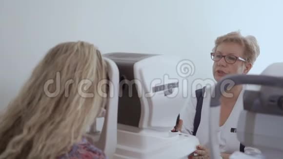 医生用现代设备检查年轻妇女的视力视频的预览图