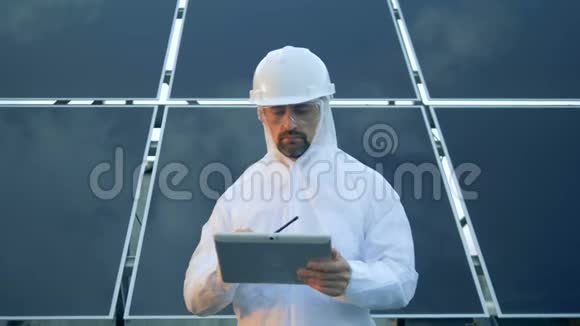男太阳能工程师站在太阳能组件前面在发射机上讲话视频的预览图