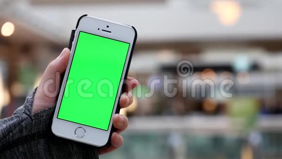 女人拿着绿色屏幕手机和模糊的人在食物场吃饭的动议视频的预览图