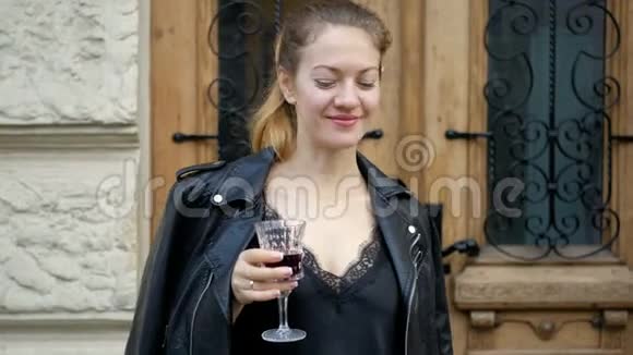 年轻的女人从水晶杯里喝葡萄酒享受一杯饮料路上成功人士的休闲视频的预览图