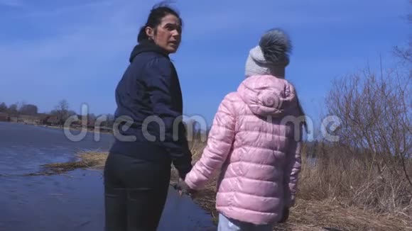 春天妈妈和小女孩在湖边视频的预览图