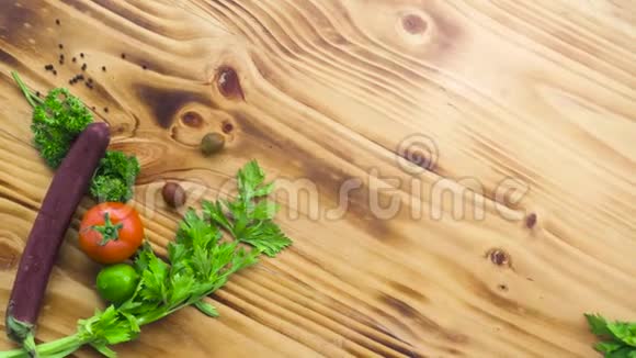 木制桌子上的食物成分来自新鲜蔬菜调味品和草药把新鲜的西红柿茄子和视频的预览图