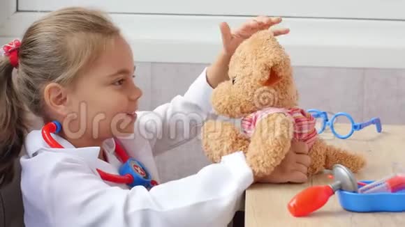 可爱的小女孩和泰迪熊玩医生视频的预览图