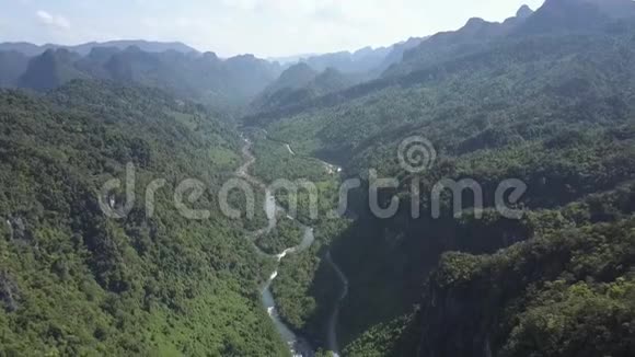 在绿色丛林山之间蜿蜒的河流全景视频的预览图