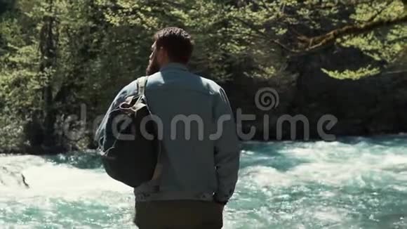人在林地里看着大自然站在镜头前对着河流视频的预览图