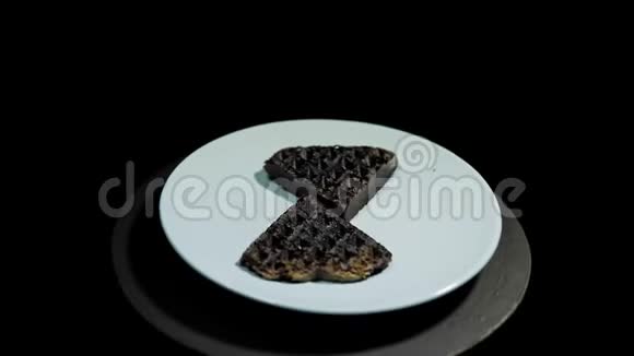 盘子上的深色心形华夫饼打开黑色背景视频的预览图