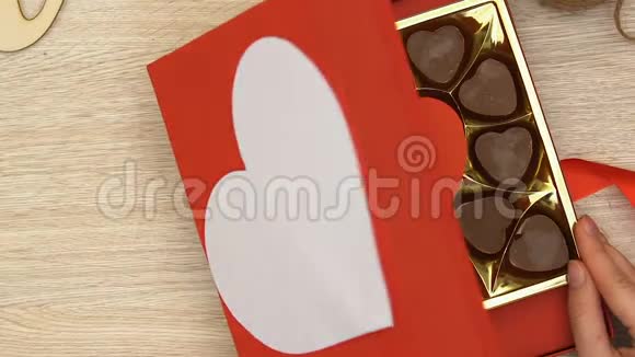 提供心形巧克力糖果壮阳药的女性开放礼品盒俯视视频的预览图