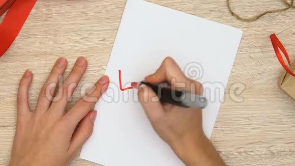 女人在纸上写着爱的词男人和女人的浪漫关系视频的预览图
