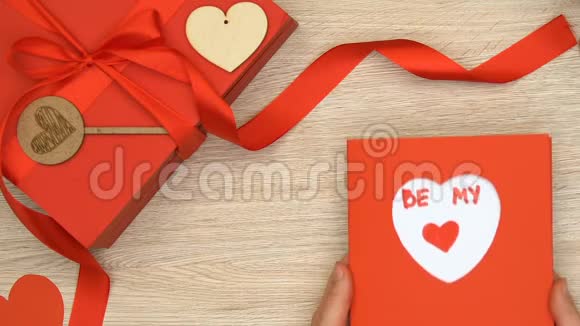 双手拿着情人节卡片和我的文字放在桌子上的礼品盒浪漫视频的预览图