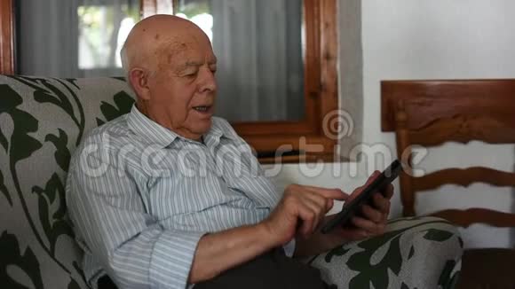 老人在家使用智能手机视频的预览图
