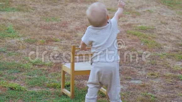 小男孩在户外的椅子上走路视频的预览图