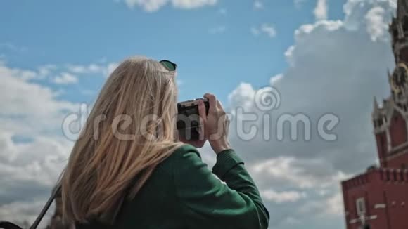 俄罗斯莫斯科克里姆林宫斯帕斯卡亚塔拍照的金发女游客视频的预览图