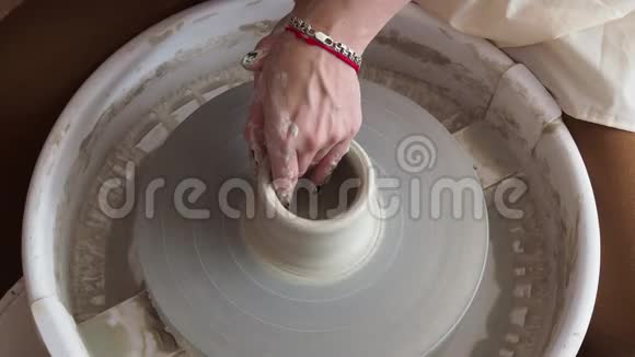 年轻陶工的手是在陶罐的范围内生产的视频的预览图