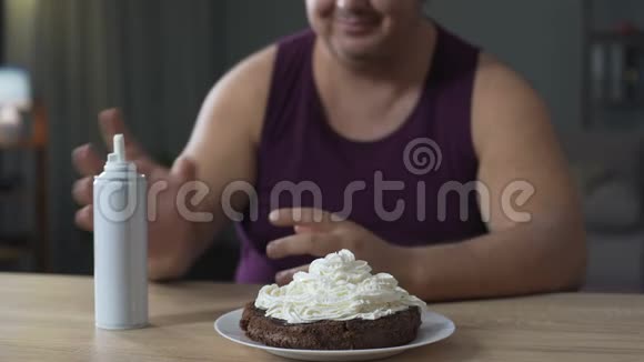 胖男人用鲜奶油和樱桃装饰蛋糕视频的预览图