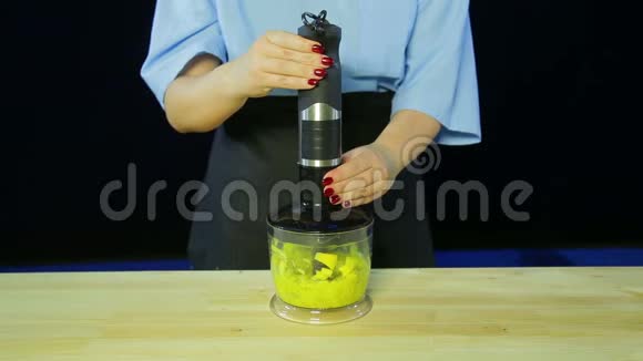 一个女人在搅拌机里切碎猕猴桃和芒果视频的预览图