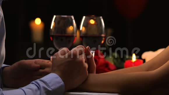 男人温柔地握住女人的手抚摸她的手指浪漫的约会调情视频的预览图