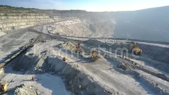 鸟瞰式自卸卡车在采石场露台上卸下岩石视频的预览图