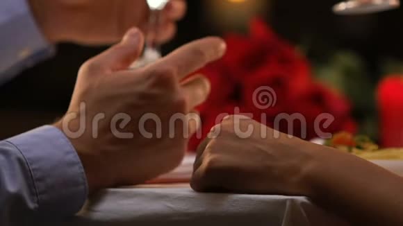 男人温柔地向心爱的女人敬酒牵着她的手爱情人节视频的预览图