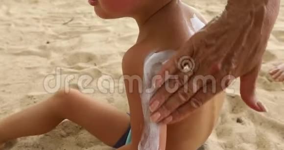 妈妈在孩子的肩膀上涂抹防晒霜视频的预览图