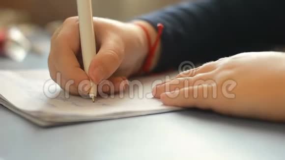 小女孩在笔记本上写字特写视频的预览图