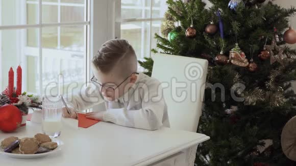 可爱的小男孩给圣诞老人写愿望清单视频的预览图